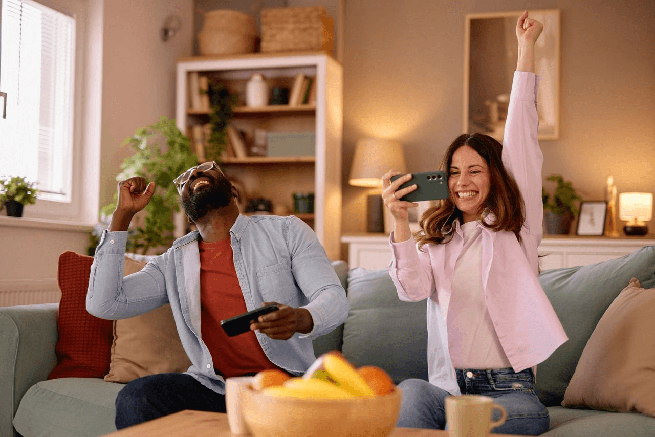 A couple cheering together during a playful evening at home